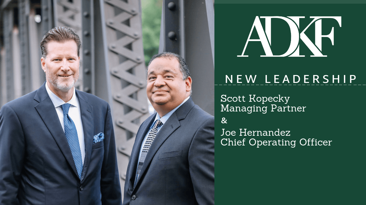 Two men in business suits outdoors.