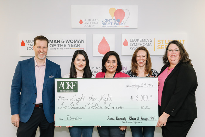 Group holding large donation check.