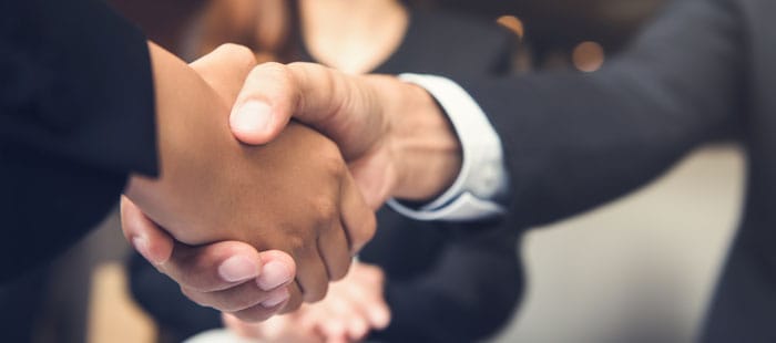 Handshake between diverse individuals.