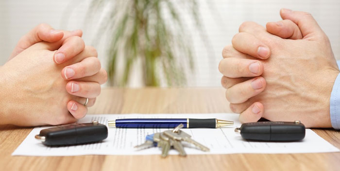 Two hands clasped over documents