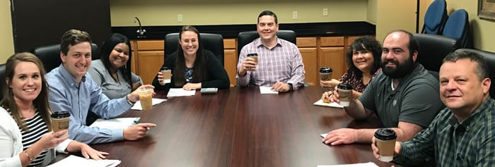 Group meeting with coffee cups.