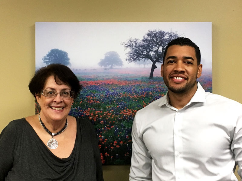 Two people in front of artwork.