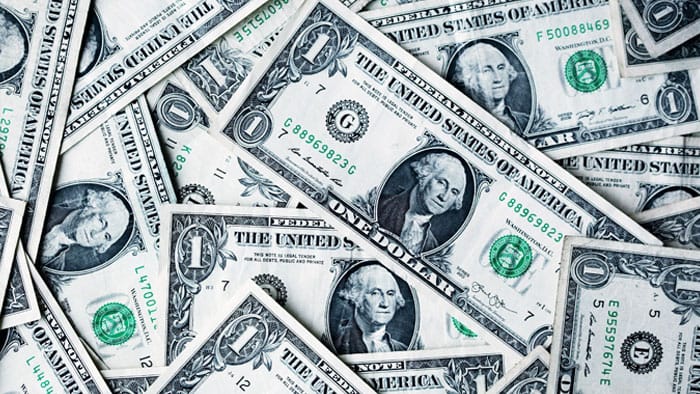 Scattered one-dollar bills on surface.
