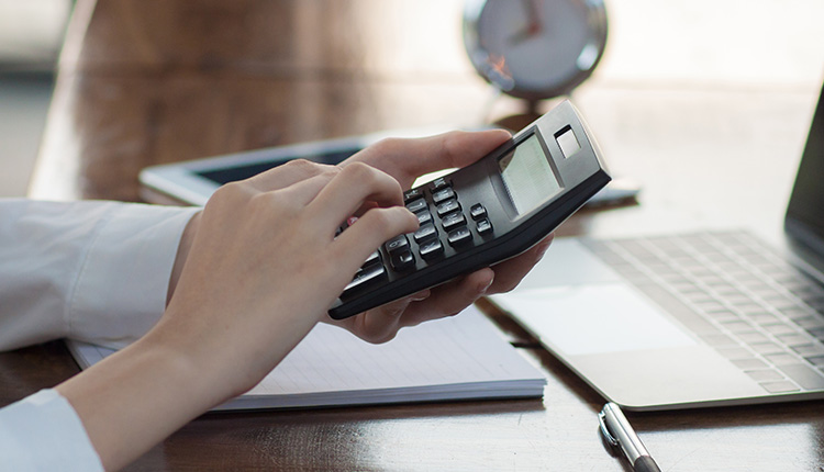 Person using calculator at desk