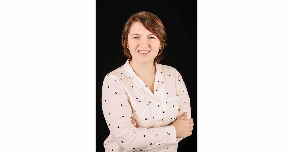 Person with arms crossed, polka dot shirt.