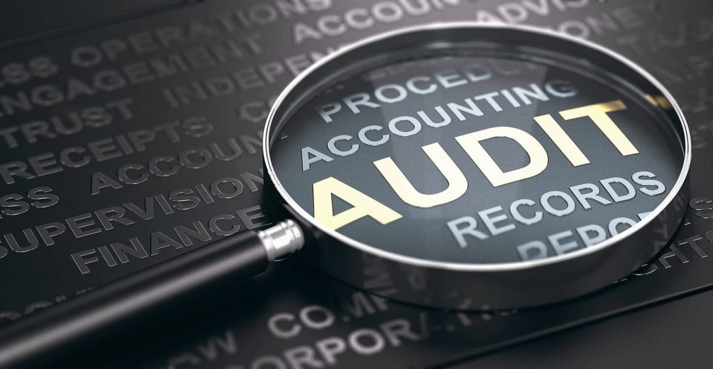 Magnifying glass over audit documents