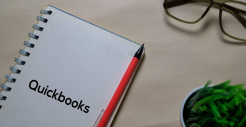 Notebook with Quickbooks title and pen.