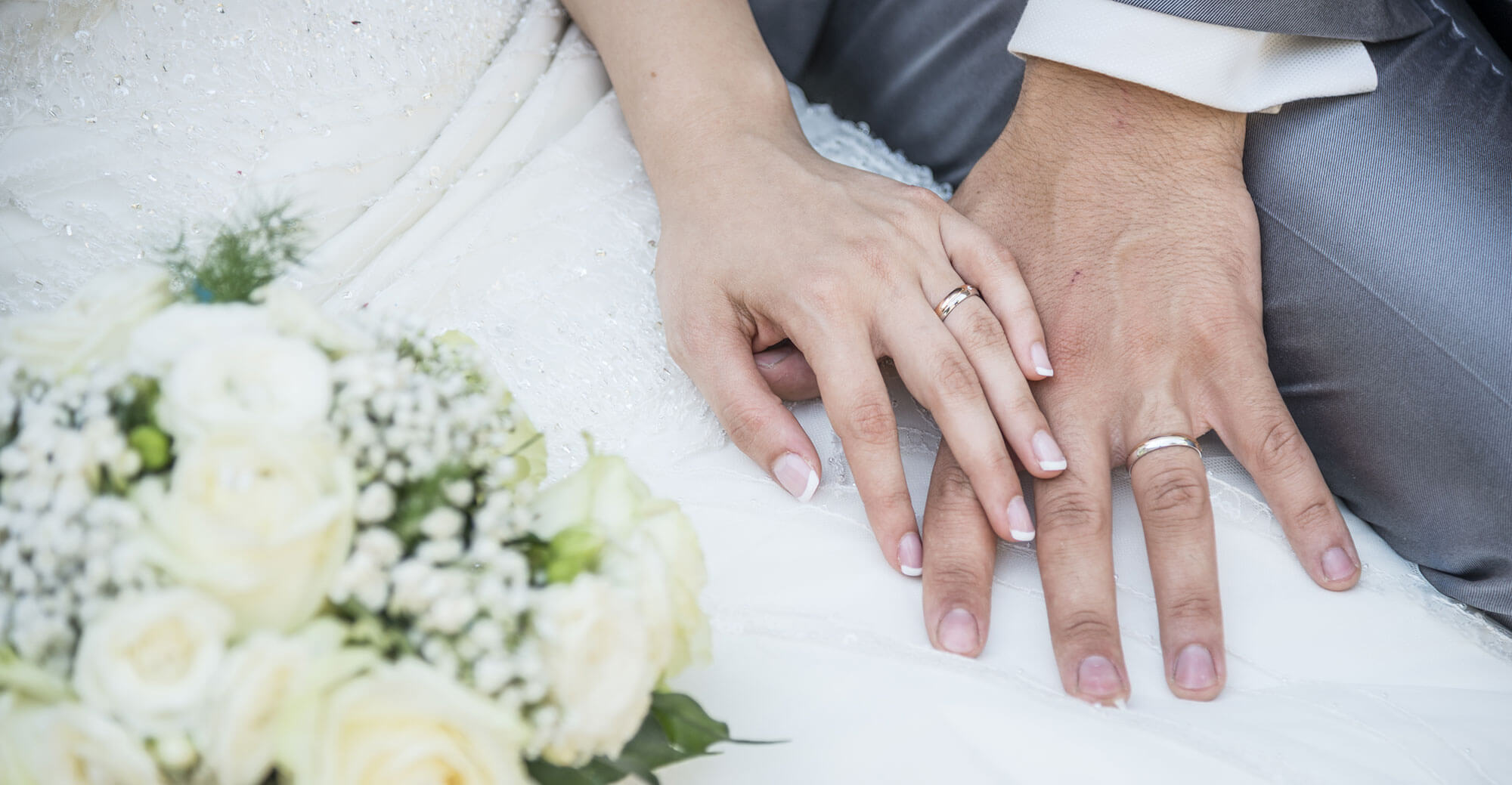 Couple's hands with wedding rings.