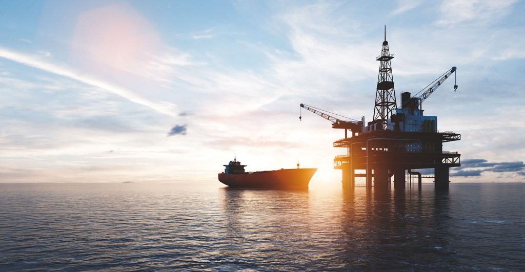 Oil rig and ship at sunset.