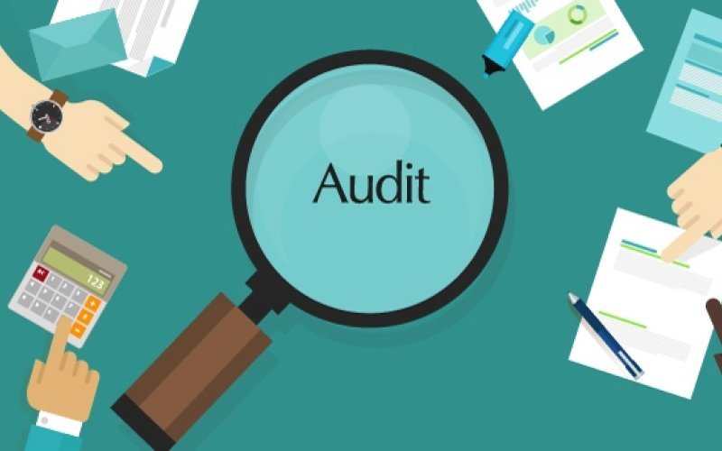 Magnifying glass over audit documents