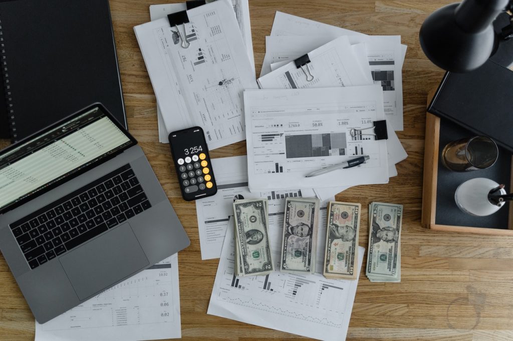 Laptop, money, and financial documents.