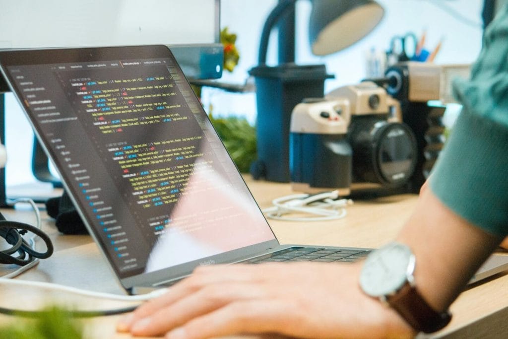 Person coding on a laptop.