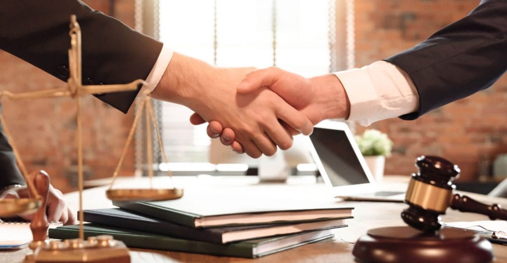 Handshake over legal documents and gavel