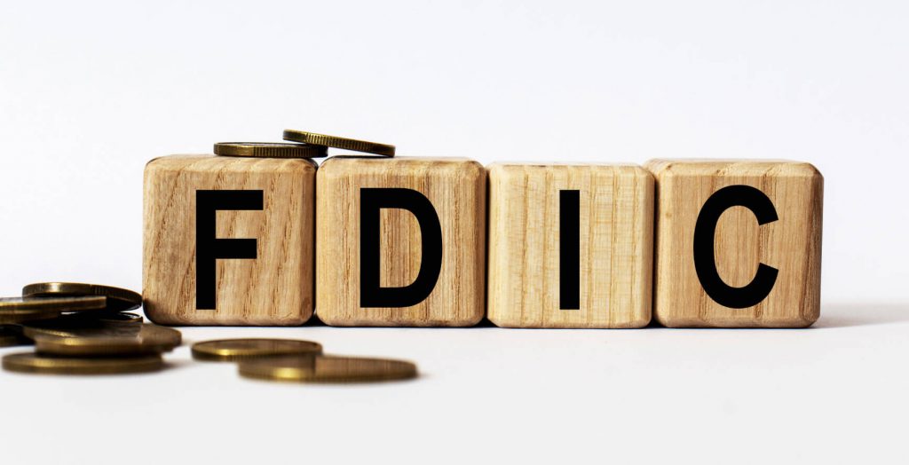 Wooden blocks spelling FDIC with coins