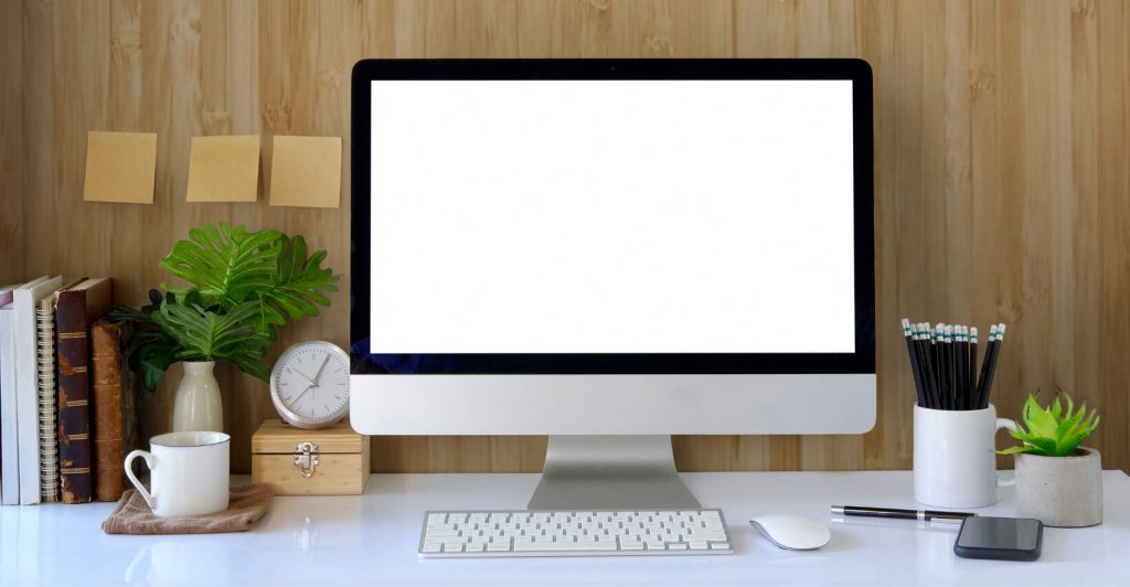 Minimalist workspace with computer and plants.