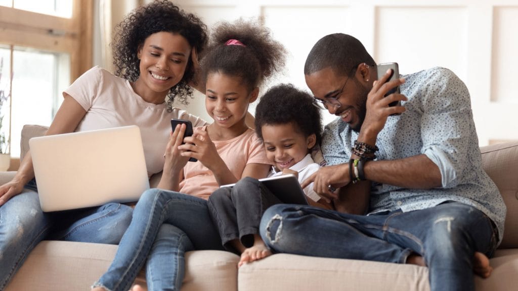 Family engaged with digital devices together.