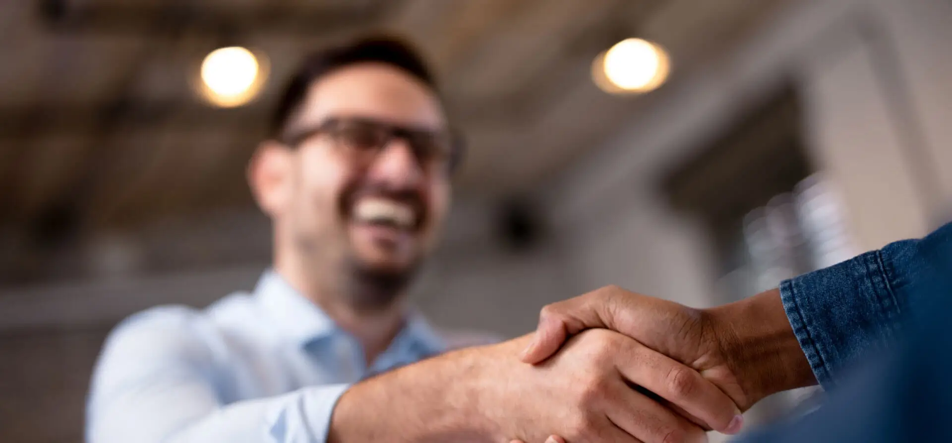 Two people shaking hands indoors.