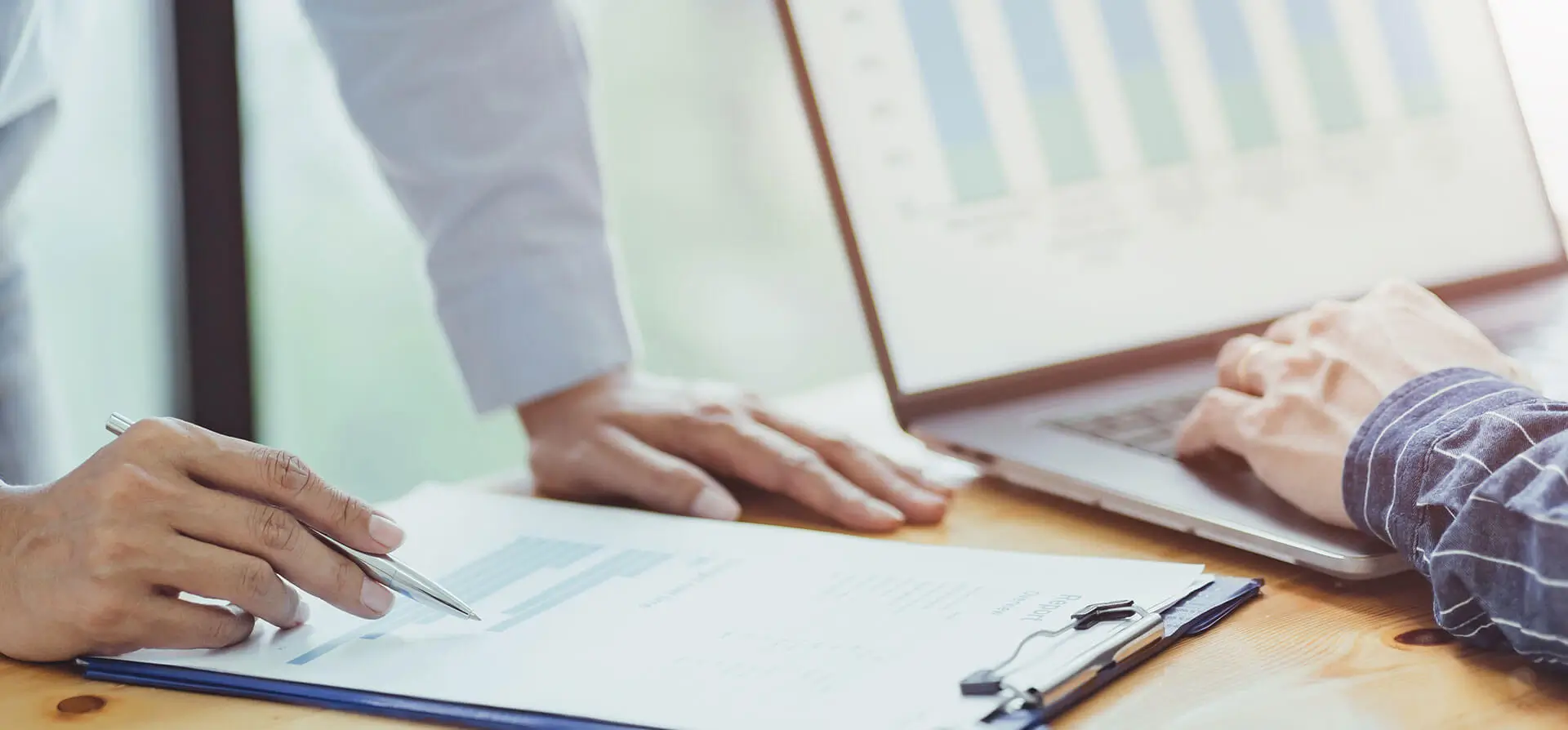 Hands analyzing financial documents and data