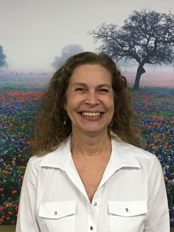 Person in white shirt, nature background.