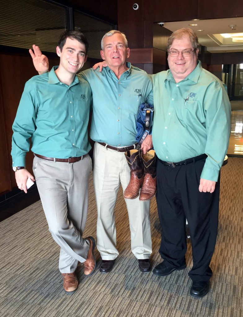 Three men in matching green shirts.