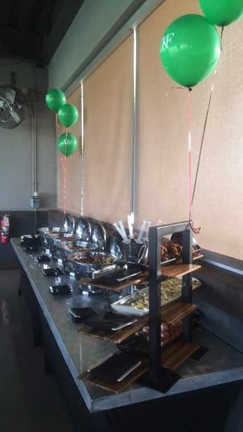 Buffet table with food and balloons.