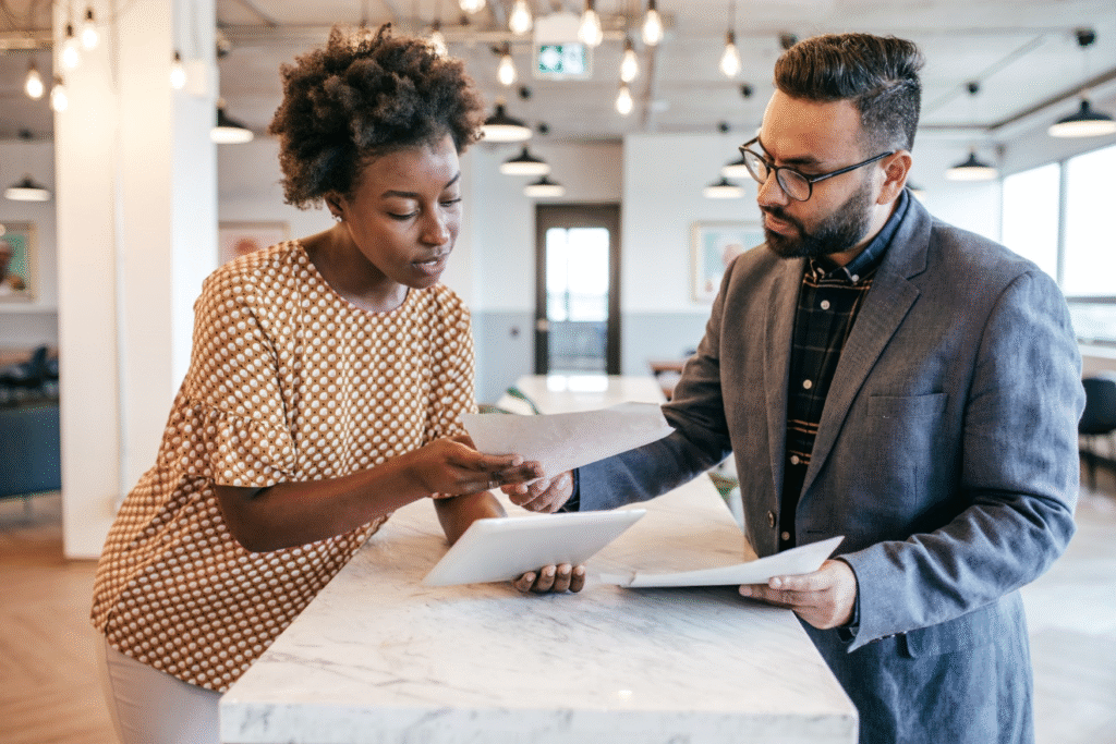 Two people discussing documents at table.